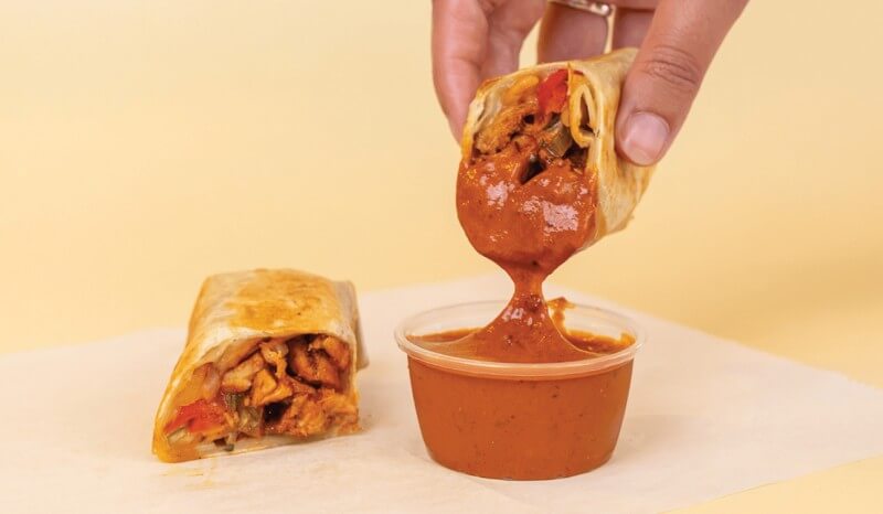 Anna's Taqueria Chipotle Chicken Taquito dipped in chipotle sauce